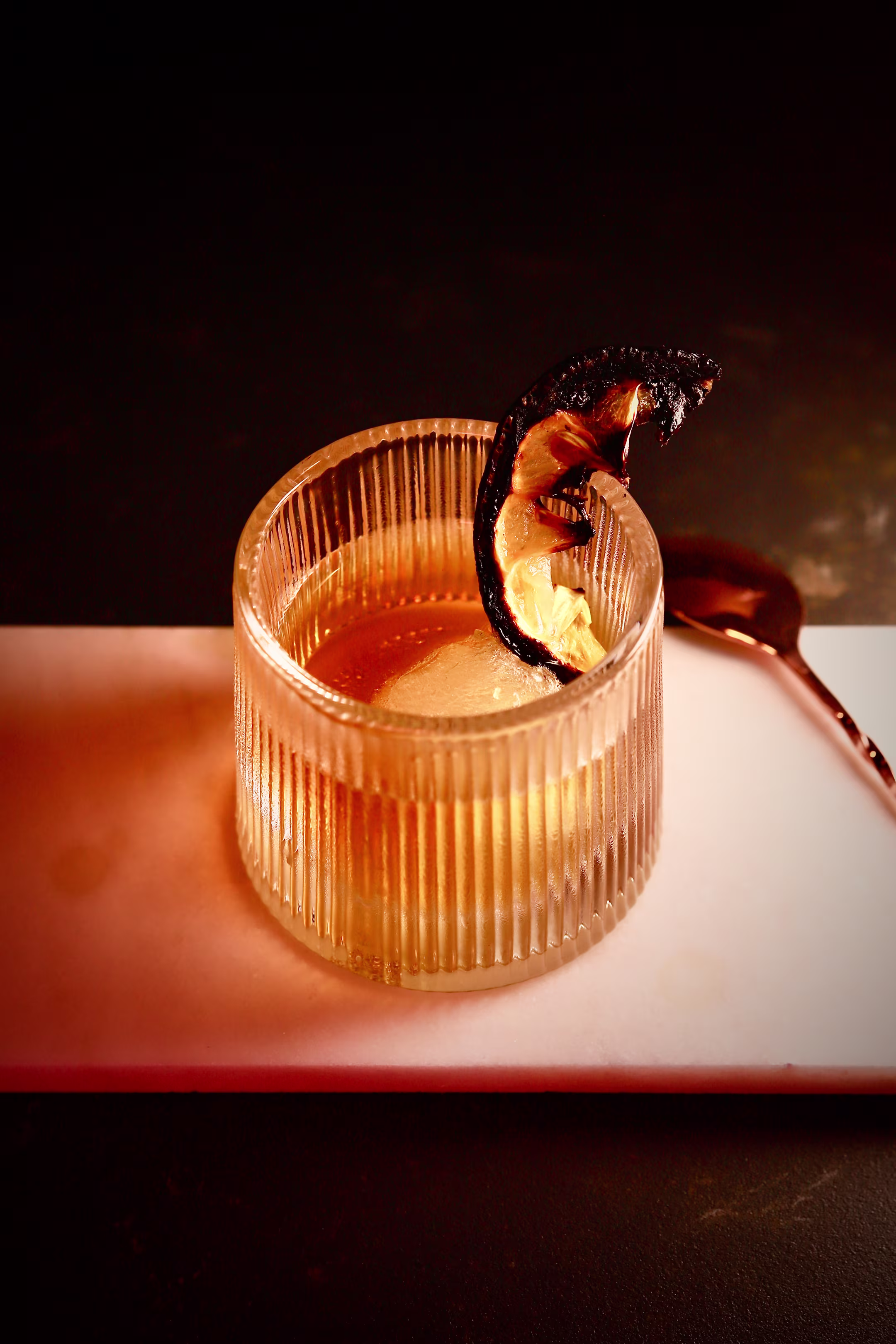 Smoked Maple and Chocolate Old Fashioned cocktail with orange peel and dark chocolate shaving.